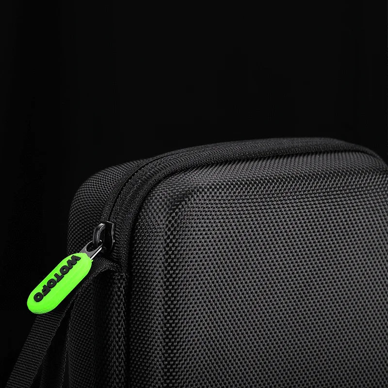 Close-up of textured black vape carry case with green zipper pull on black background